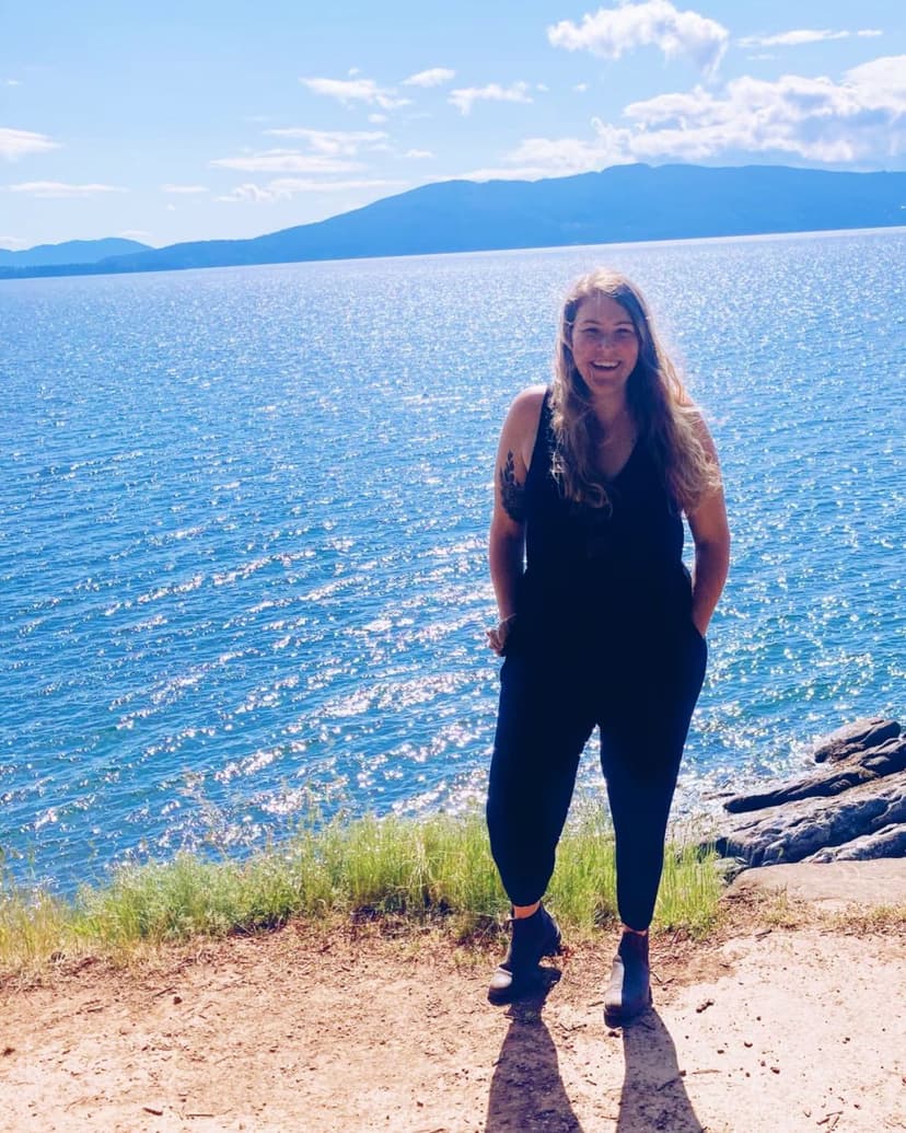 Amanda is standing on the cliff with big smile